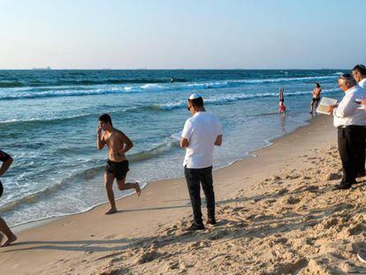 Israelíes religiosos rezan en el año nuevo judío mientras otros corren en una playa de Ashdod.