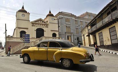 Un coche frente a la sala de conciertos Dolores, en una antigua iglesia de la plaza homónima, en Santiago de Cuba.