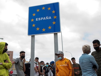 Varios migrantes esperan para pasar la frontera entre Ceuta y Marruecos voluntariamente.