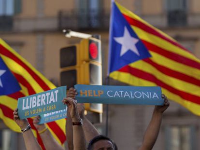 Dos personas lenvantan sus pancartas en la manifestaci&oacute;n convocada por la Mesa por la Democracia en Barcelona.
