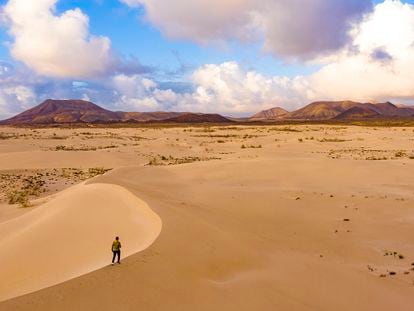 Un caminante entre dunas por el parque natural de Corralejo, en la isla canaria de Fuerteventura.