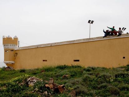 Un grupo de niños saluda desde el centro de menores de La Purísima, en Melilla, un antiguo fuerte militar.