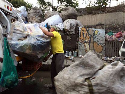 Un trabajador de limpia colecta basura en la Ciudad de M&eacute;xico.