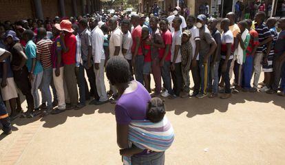 Una multitud de ciudadanos hace cola frente a un supermercado en Harare, Zimbabue, el 25 de marzo de 2020.