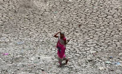 Una mujer camina por una zona seca del río Sabarmati, en un caluroso día en Ahmedabad (India).
