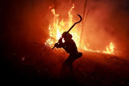 Bomberos intenta apagar el incendio en Piedrafita (Asturias), el viernes. 