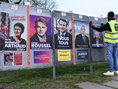 Un empleado de una empresa de publicidad coloca varios carteles electorales de los candidatos a la Presidencia de Francia, este lunes en Saint-Herblai.