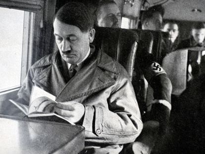 Adolf Hitler, líder del partido nazi, leyendo en el interior de un avión.