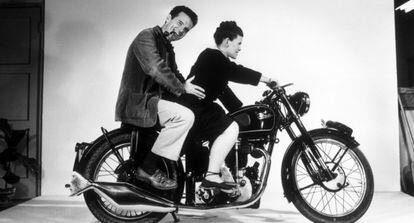 Charles y Ray Eames, posando sobre una motocicleta, en un fotograma del documental.