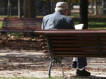 Un jubilado lee el periódico en un parque de Madrid.