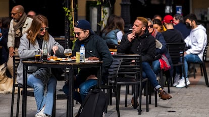 Una persona fuma en la terraza de un bar, en la plaza de Santa Ana de Madrid.