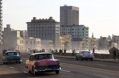 Conches antiguos circulando frente al Malecón de La Habana.