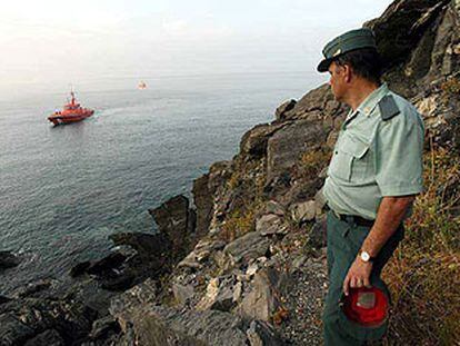 Un guardia civil observa desde la costa de Salobreña la zona donde fueron interceptados 14 inmigrantes.