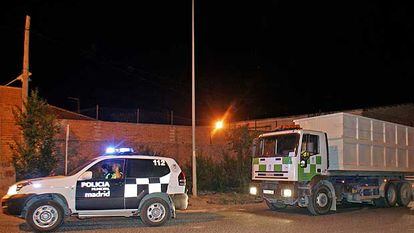 Un vehículo de la Policía Municiapl acompaña a varios camiones de basura a su paso por la Cañada Real Galiana.