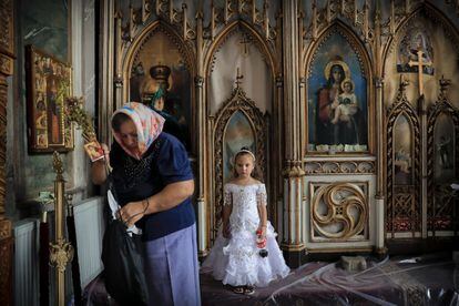 En Rumanía, viven algo más de 620 000 romaníes. En la imagen, una niña espera a su madre, después de pasar por el altar de una iglesia de Costesti (Rumanía).