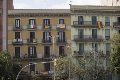 Diferentes banderas cuelgan de los balcones de la Plaza de Tetuán, en Barcelona.