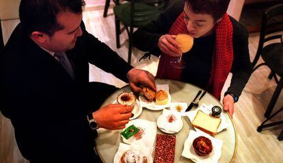 Una pareja desayuna con varios productos de bollería