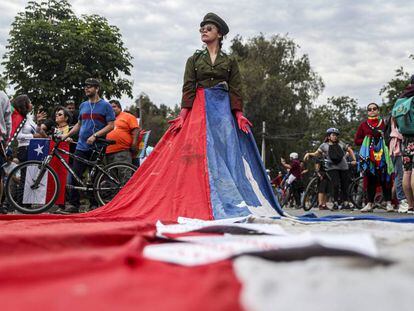 Una mujer, vestida de militar y envuelta en la bandera de Chile, en las protestas del pasado domingo 27 de octubre en Santiago.  