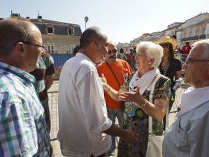 El diputado general de Gipuzkoa, Martín Garitano (centro), y el alcalde de San Sebatián, Juan Carlos Izaguirre (izquierda), saludan a representantes de la asociación de familiares de presos de ETA Etxerat invitados al inicio de las fiestas de Vitoria.