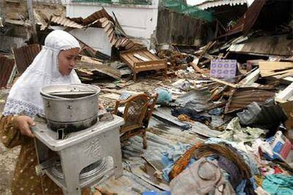 Una mujer recoge ayer sus pertenencias en su casa destruida por el terremoto en la isla de Nias.