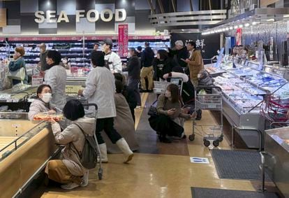 Varios clientes de un supermercado se agachan tras sentir una sacudida durante el terremoto en un supermercado de la ciudad de Toyama, en la prefectura del mismo nombre, este lunes. 