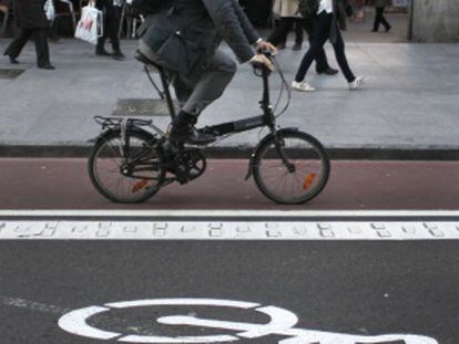 Un ciclista utliza el carril bici para ir al trabajo.