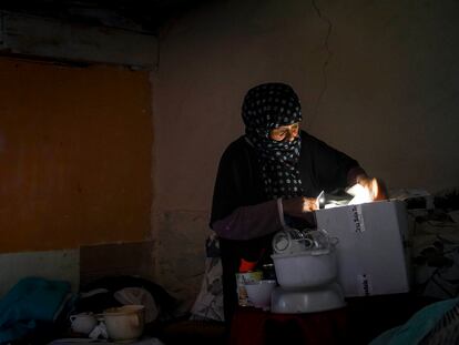 Ibilya busca papeles a la luz del móvil en el interior de su chabola en el sector VI de la Cañada Real.