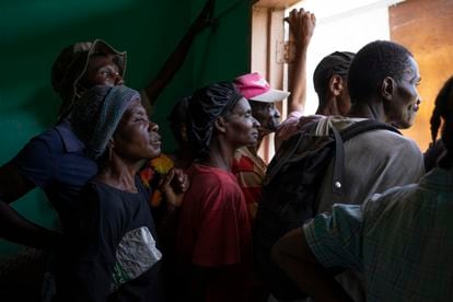 A group of victims waits for one of the food deliveries from the World Food Program, in the community of Maniche, where at least 177 people died.