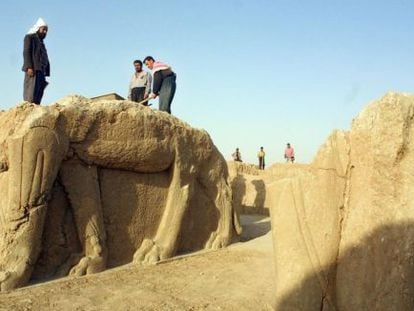 Treballadors netegen una estàtua en un jaciment arqueològic a Nimrud.