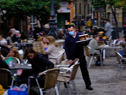 Un camarero atiende varias mesas en Sevilla.