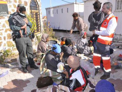Guardia Civil y Cruz Roja atendiendo a algunos de los 45 inmigrantes llegados a Ceuta.