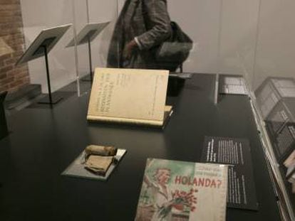 Guía turística de Holanda (en primer plano), tirador de madera (izquierda) y tratado de botánica de Ana Frank, objetos incorporados a la exposición 'Auschwitz'.