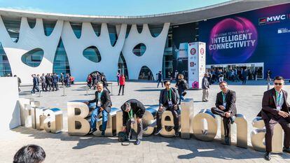 Asistentes al Mobile World Congress de 2019 se toman un descanso en los exteriores de la Fira de Barcelona.