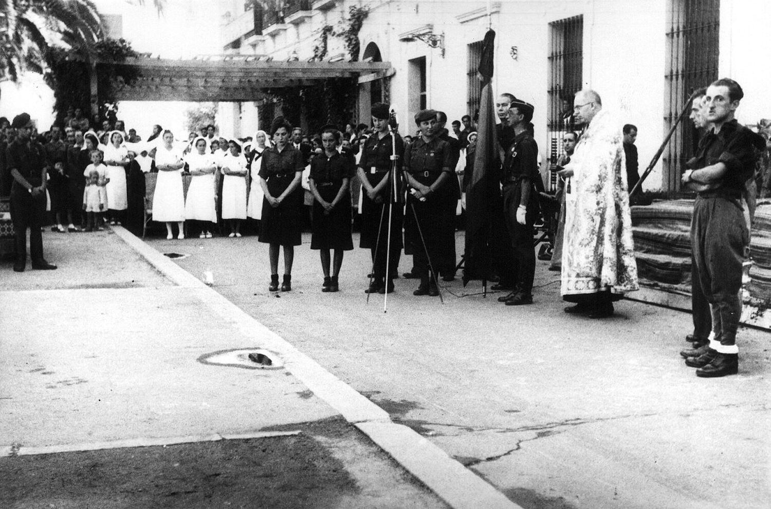 Entrega de una bandera nacional en un acto de Falange de Badajoz, durante la Guerra Civil.