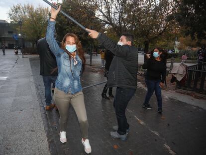Un grupo de seis aficionados a la salsa baila son cubano en la plaza de la Puerta de Toledo.