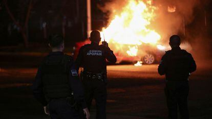 Agentes de policía frente a un auto incendiado por miembros del Cártel Jalisco Nueva Generación, en Zapopan, Estado de Jalisco (México), el 9 de agosto de 2022.