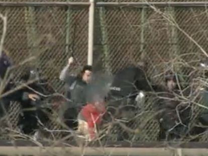 Fotograma del vídeo donde se ve cómo un migrante es apaleado por varios agentes tras bajar de la valla fronteriza de Melilla.