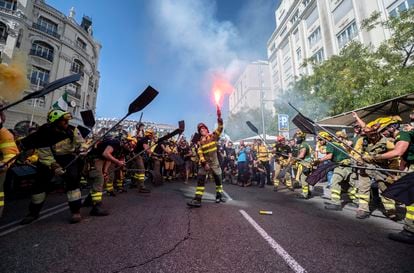 Bomberos y brigadas forestales simulan que apagan un fuego con sus palas mientras se manifiestan, este sábado en Madrid.