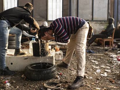 Migrantes argelinos se lavan con una garrafa de agua en una nave industrial el pasado enero, en Velika Kladuša, una ciudad cercana al campo de Bihac, las dos en Bosnia y Herzegovina.