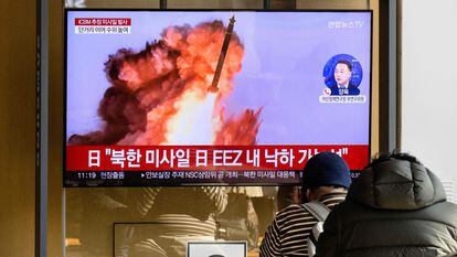 Varias personas observan una pantalla que emite imágenes del misil lanzado por Corea del Norte, este viernes en una estación de trenes en Seúl.
