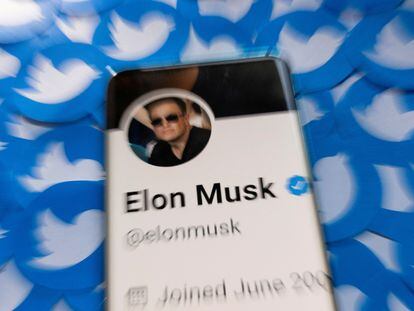 El perfil de Elon Musk en Twitter, mostrado en un teléfono móvil sobre logotipos de la red social.