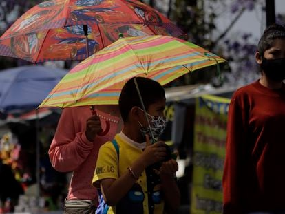 Transeúntes se cubren con sombrillas para mitigar el calor en la Ciudad de México, en marzo de 2022.