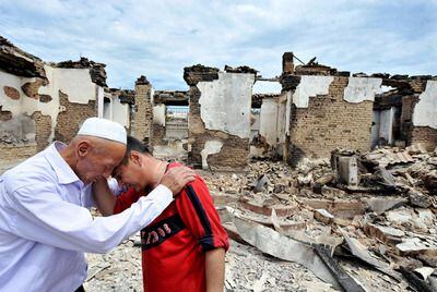 Unos uzbekos lloran ante una casa destruida en el pueblo de Shark (Kirguizistán) en junio de 2010.