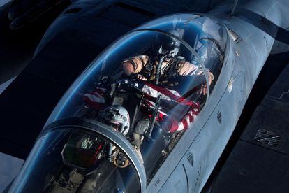 Un piloto del F-15E 'Strike Eagle' de EE UU muestra una bandera estadounidense mientras realiza una misión de patrulla aérea de combate en un lugar no revelado en el suroeste de Asia.