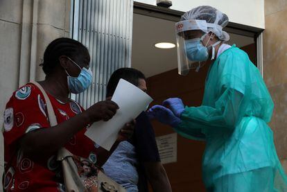 Una sanitaria atiende a varias personas en el exterior de un centro de emergencias en Lleida.