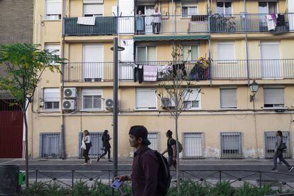 Peatones pasan por delante de un bloque de pisos en la calle Calvario de Pozuelo de Alarcón, Madrid.