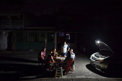 Un grupo de hombres juega al dominó el lunes durante un corte parcial de energía en San Cristóbal (Venezuela).