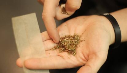 Un noi fent-se un porro de marihuana.