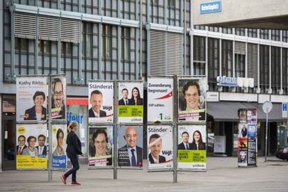 Una mujer pasa delante de carteles electorales, en Zurich, el 28 de septiembre.