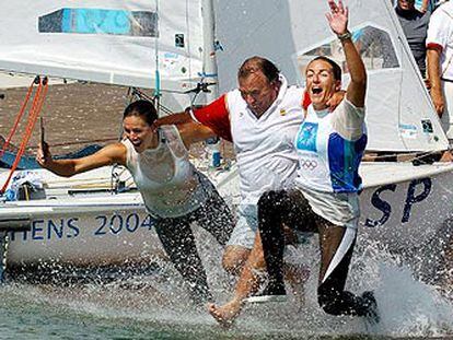 Natalia Vía-Dufresne (a la derecha) y Sandra Azón se lanzan al agua junto al director del equipo olímpico español, José María Benavides, tras conquistar la medalla de plata en la clase <i>470</i>.